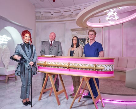 Four smiley undertakers surround a pink coffin.