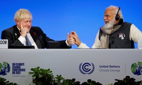 The UK prime minister, Boris Johnson, and India's Narendra Modi holding hands next to climate change sign