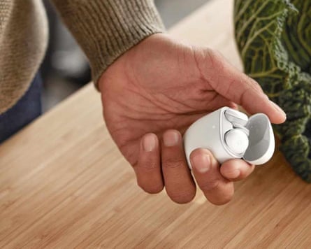 close-up of person holding earbuds in white case