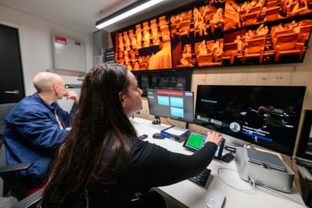 رجل وامرأة ينظران إلى مجموعة من الشاشات