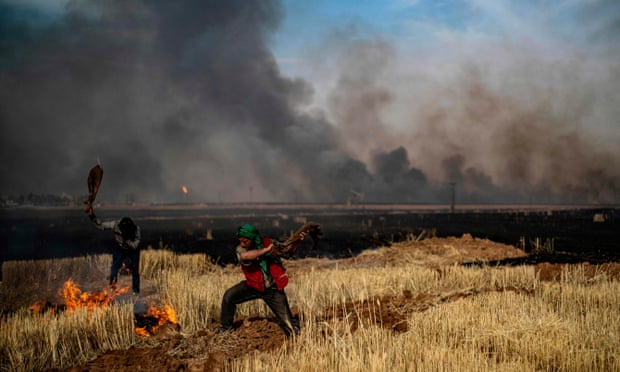 Koerdische boeren bestrijden een brand in een tarweveld in de noordoostelijke provincie Hasakah, een graanschuur voor de regio.