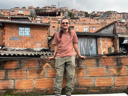 Róbinson Velásquez Cartagena standing against a wall against a backdrop of closely packed houses.