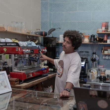 Hassan standing behind counter next to coffee machine
