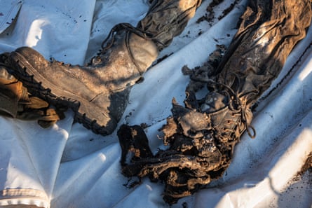 Closeup of a pair of blackened boots partly blown apart by a mine.