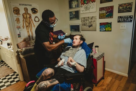 A man brushing a man in a wheelchair’s teeth