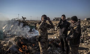 Des soldats irakiens se tiennent près d'un feu sur la route principale de Erbil à Mossoul mercredi. Les États-Unis a déclaré qu'il avait lancé une attaque contre un hôpital de Mossoul où les combattants Isis fonctionnaient.