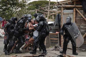 Police agents arrest a man while his wife and family resist, during evictions of people from the San Isidro settlement in Puerto Caldas, Colombia, on 6 March 2021