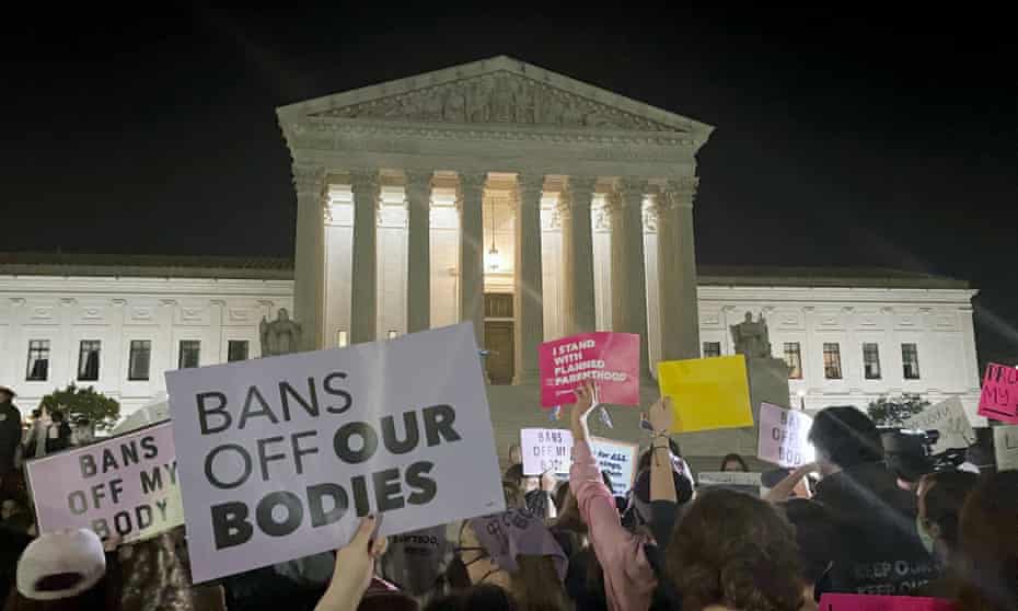 A crowd of people gather outside the US Supreme Court in Washington DC on Monday night.