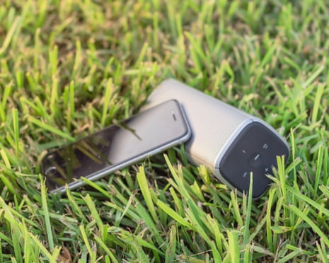 Typical smart phone and Bluetooth speaker on grass lawn nature environment2AWK7C8 Typical smart phone and Bluetooth speaker on grass lawn nature environment