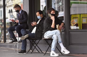 Men queue for a haircut outside a barber shop in Melbourne, Australia