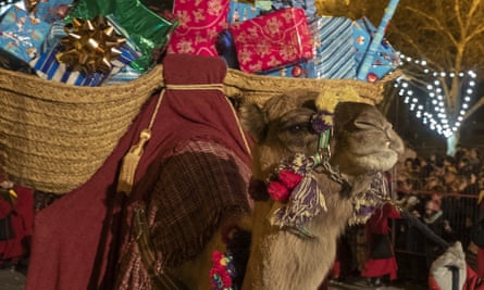 A camel carrying gifts is led though the streets during the Epiphany parade in Madrid, Spain, 5 January 2020.