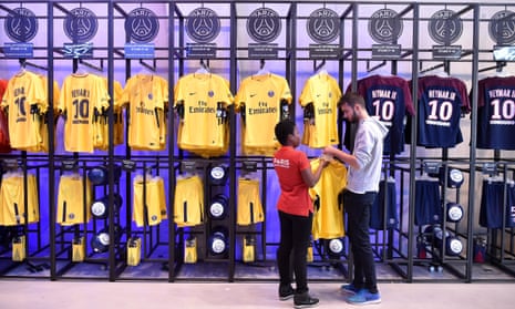 Employees of the official Paris Saint-Germain (PSG) store display the new jerseys of Brazilian striker Neymar Jr.