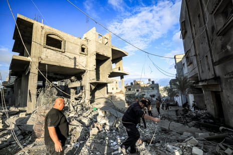 People inspect the rubble of a building where the displaced Palestinian Jabalieh family were sheltering in Rafah.