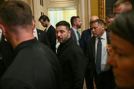 Men in suits walk in an ornate corridor