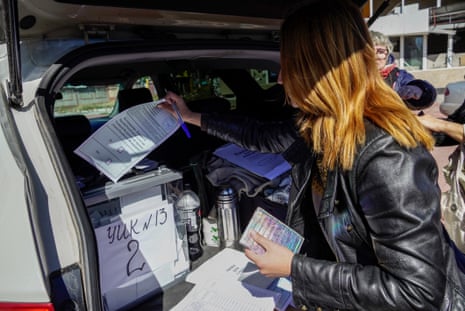 A woman casts a ballot in the back of a car during the “referendum” in occupied Mariupol.