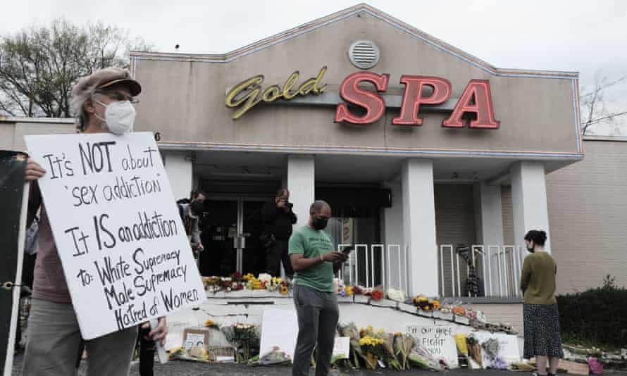 People hold signs and mourn the victims outside Gold Spa in Atlanta on March 18.