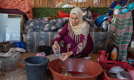 Rihan Nawaja washes dishes in the tent that serves as their new home since her house was destroyed by the Israeli civil administration in Jawaya of the south Hebron hills.