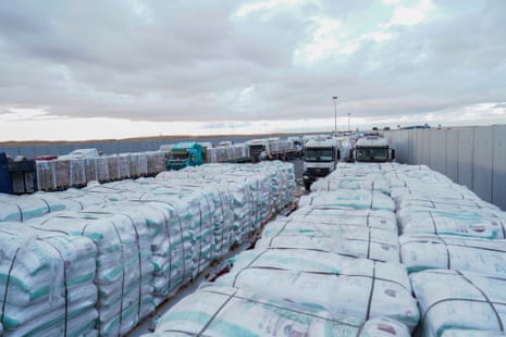 Caminhões de ajuda humanitária estão alinhados antes de seguirem em direção à passagem da fronteira de Rafah.