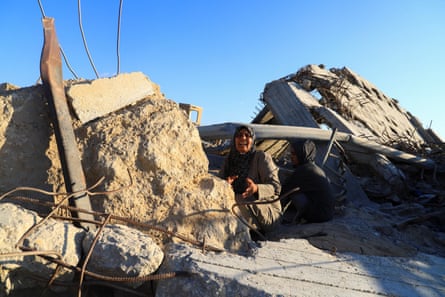 A Palestinian woman cries as she sits among rubble