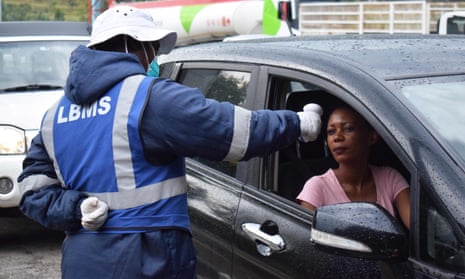A Lesotho health official takes the temperature of motorists as a preventive measure against the spread of coronavirus