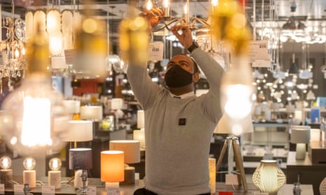 A John Lewis staff member cleaning light fittings at their White City store ahead of reopening in April 2021. 