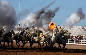Horse riders perform with guns during the El Jadida international horse show