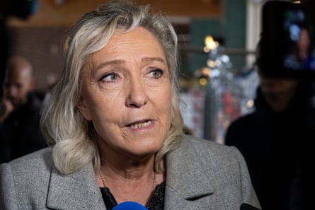 Marine Le Pen looks to the side as she is interviewed by a journalist