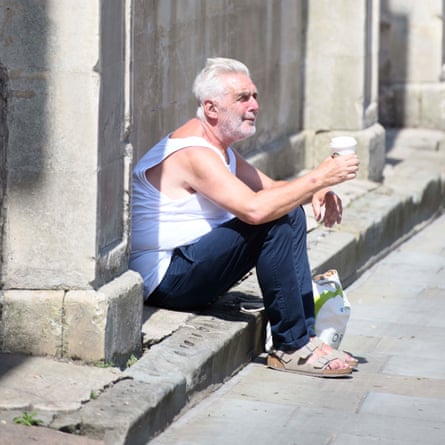A man stops for a rest on High Street.