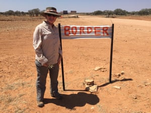 Liza Dale-Hallett next to a border sign