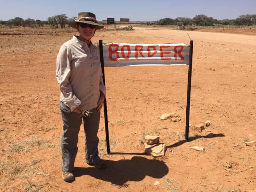 Liza Dale-Hallett next to a border sign