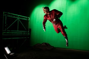 A man hangs suspended in front of a green screen