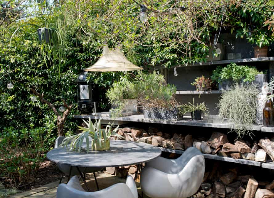 A table, chairs and a light in the garden's outdoor kitchen