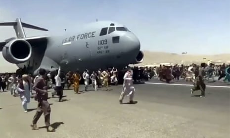 Afghans run beside a US Air Force transport plane as it tries to take off from Kabul, Afghanistan. 