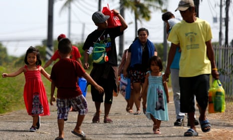 Filipino villagers evacuate a coastal village in Cavite province on Christmas Day as authorities evacuated thousands in preparation for typhoon Nock-ten.