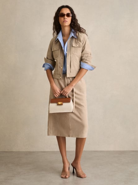 Model wearing beige suede jacket, blue shirt and beige skirt