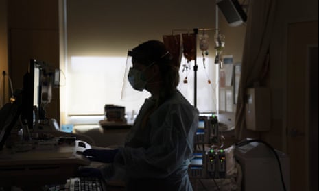 A nurse works on a computer while assisting a Covid patient in Los Angeles. The US workforce has been reduced by as much as 2.6% during the pandemic, McKinsey reported.