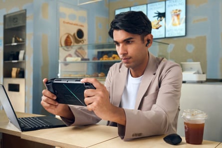 Gaming handheld ROG Xbox Ally X played at a desk.
