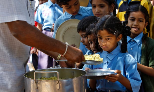 Schoolchildren queue for food at a school in Bangalore. Studies have shown that girls in India receive less education and poorer nutrition than boys.
