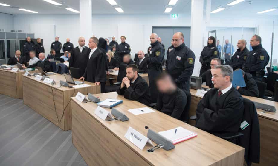 The accused sit in a courtroom in Dresden, eastern Germany.