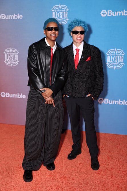 Two female athletes in suits with colorful hair.