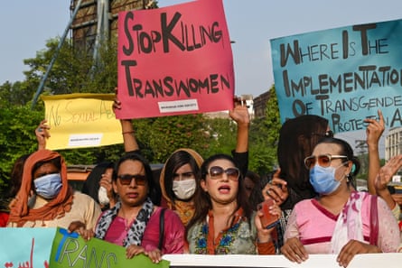 A group of people hold homemade banners reading ‘stop killing trans women’.