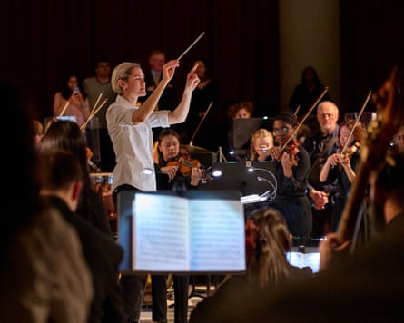 A conductor surrounded by an orchestra