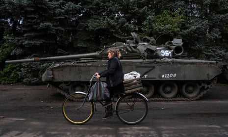A local resident rides past an abandoned Russian military vehicle in Kramatorsk, eastern Ukraine.