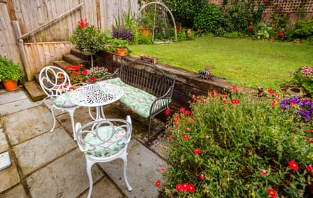 Garden patio with table and chairs and flowers in bloom