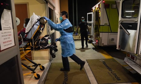 An emergency medical technician pushes a patient into an emergency room in Placentia, California.