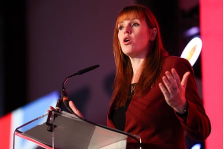 Angela Rayner in a dark red suit on stage at a conference