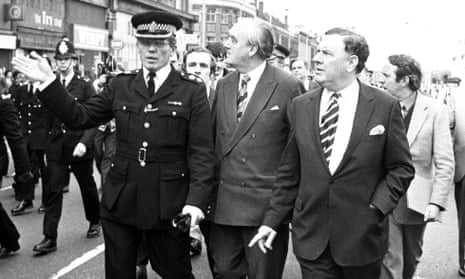 Sir David McNee, front right, and William Whitelaw, the home secretary, centre, are taken on a tour of riot-torn Brixton, south London.