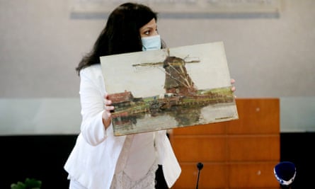 A Greek police officer presents the stolen Mondrian painting at a press conference in Athens