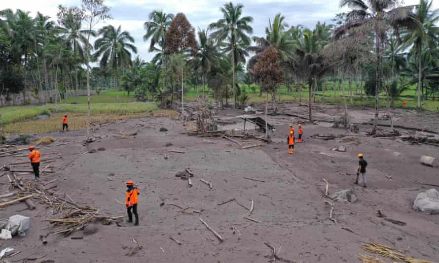 Search-and-rescue team members look for missing people on Monday at Sumberwuluh village in Lumajang