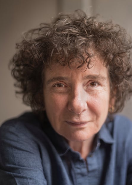 Close up of a woman with dark curly hair and a blue shirt